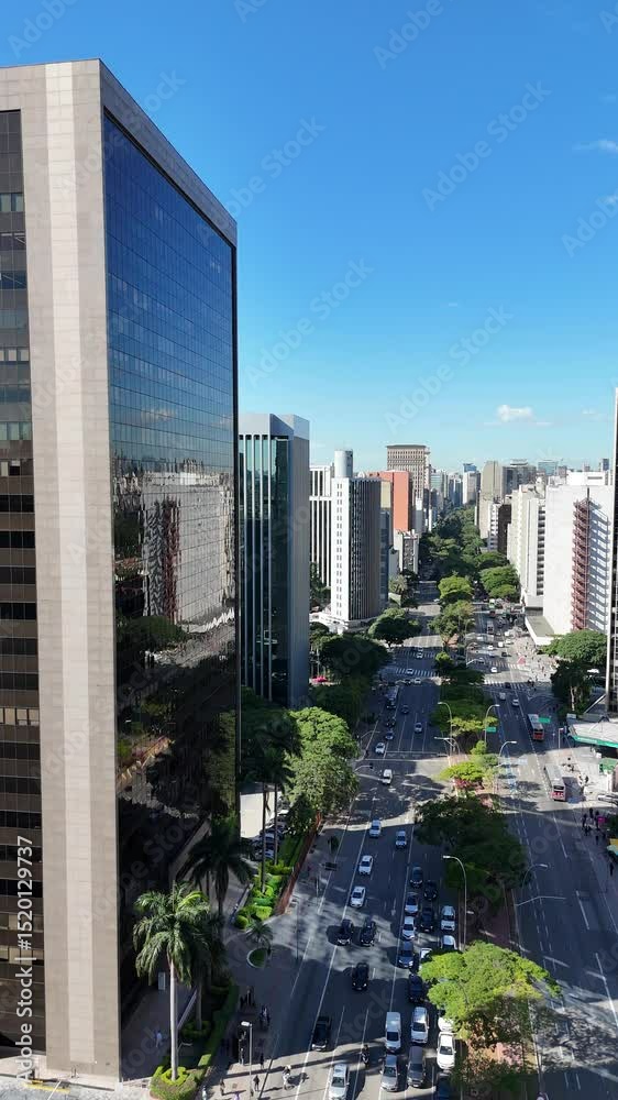 Imagem aérea vertical da Avenida Faria Lima com prédios modernos, carros, ciclovia e o centro financeiro de São Paulo