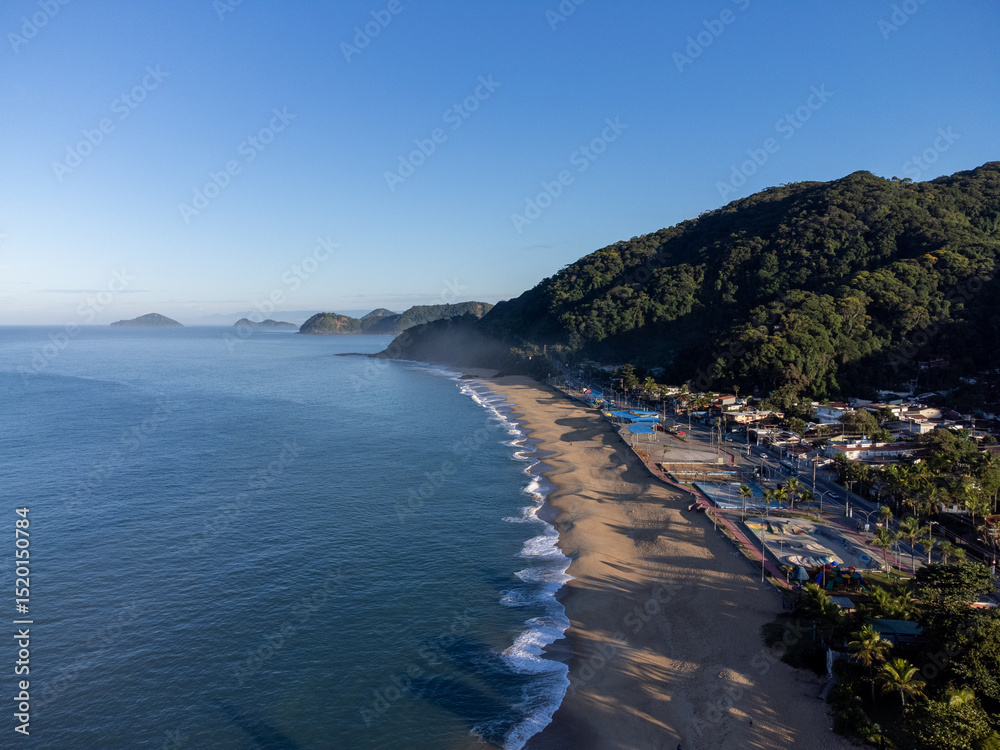 Obraz premium Amazing lighting on orange sand beach and strong waves in coastal village