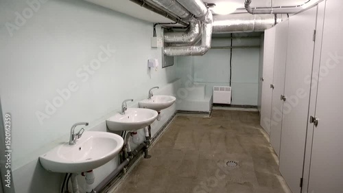 Three white washbasins opposite the toilet cubicles