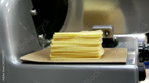 Delicious yellow cheese sliced ​​with a slicer close-up