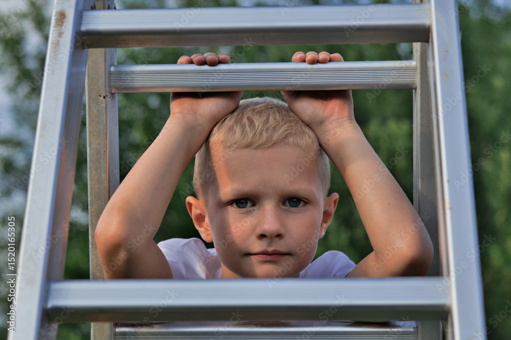 Obraz premium little boy looking through ladder