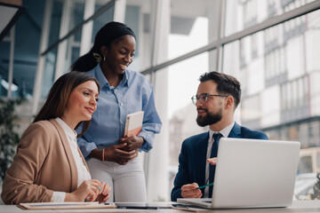 Business team discussing strategy on laptop in modern office