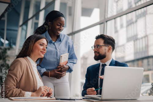 Business team discussing strategy on laptop in modern office