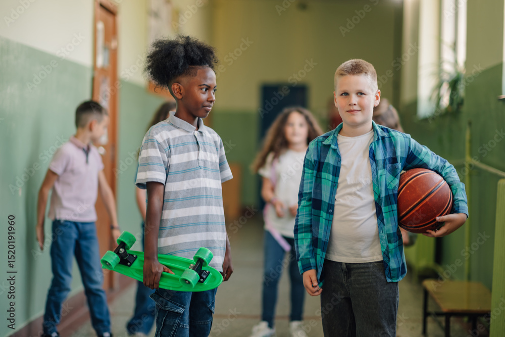 Obraz premium Students walking in school hallway holding skateboard and basketball