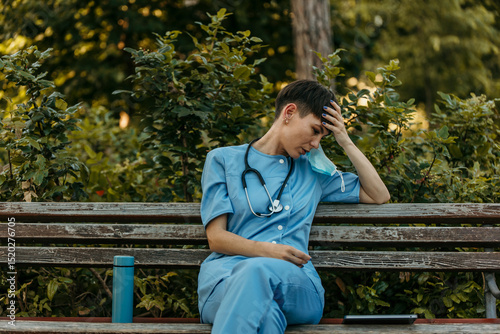 Exhausted nurse taking a break on park bench
