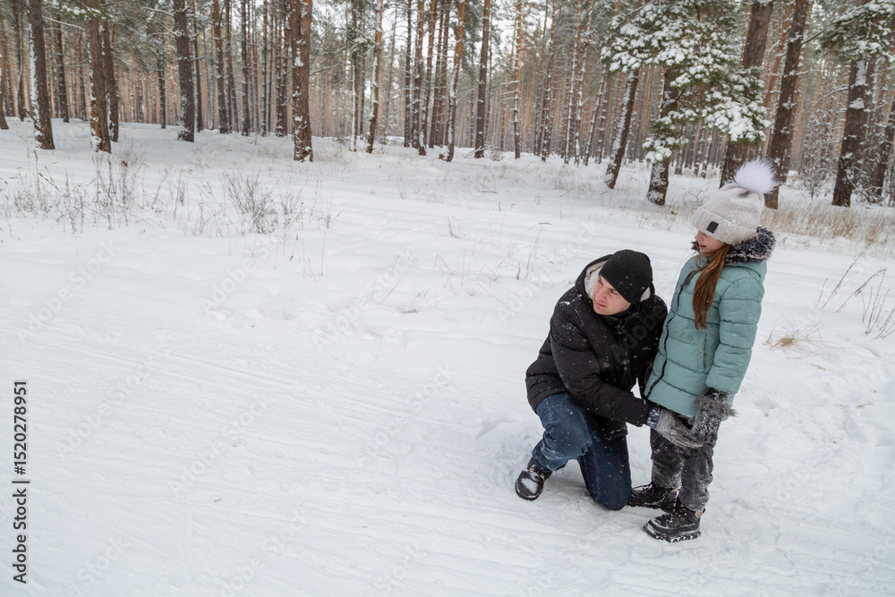 Fototapeta premium Dad and daughter walking and having fun in snowy winter forest