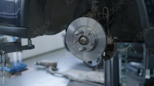 Mechanic Working on Brake Disc in Auto Repair Shop photo