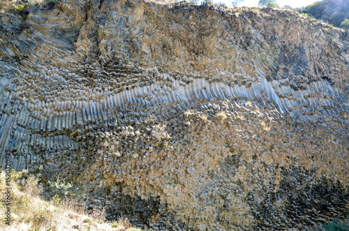 Hexagonal basalt column formations displayed on weathered cliff, showcasing unique geological patterns and structures resulting from volcanic activity and natural erosion. Symphony of stones, Armenia