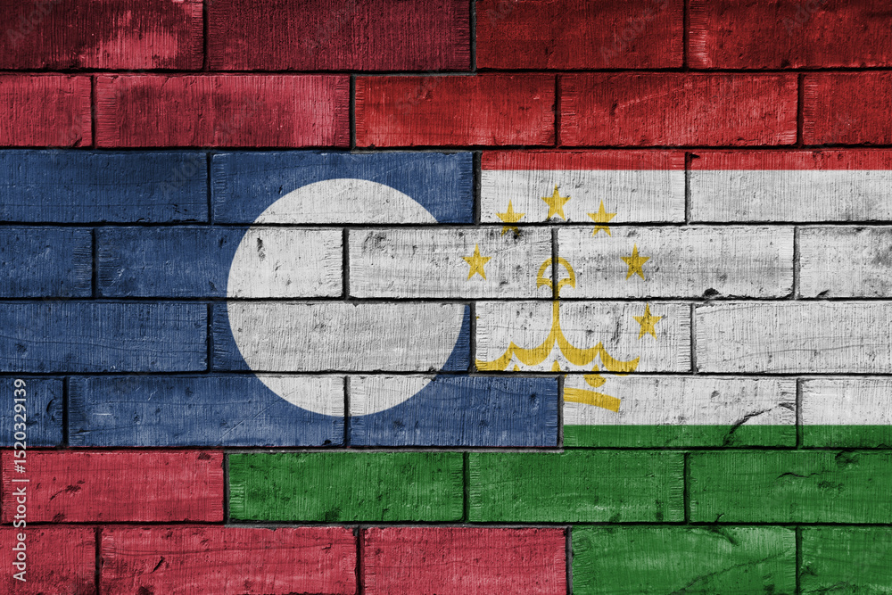 Fototapeta premium colourful painted big national flag of tajikistan and flag of laos on a massive old brick wall background. concept