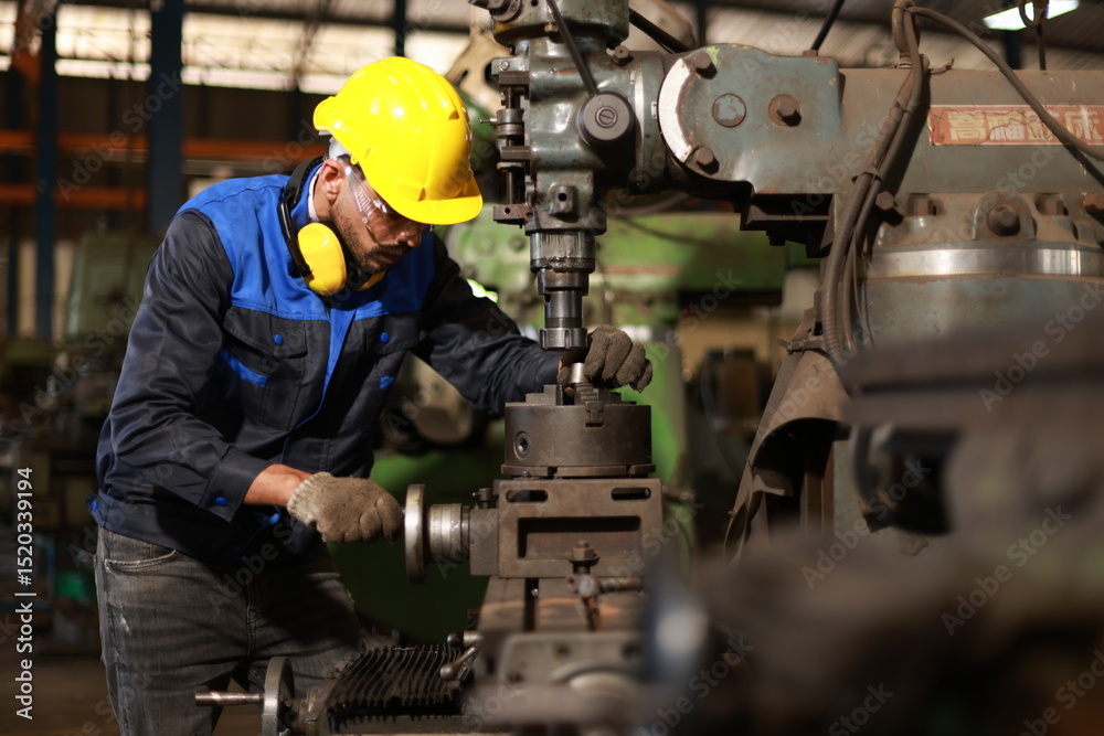 Factory male worker. Engineer man worker in plant production drilling at machine in smart factory wearing yellow hard hat safety first at mechanic factory. 