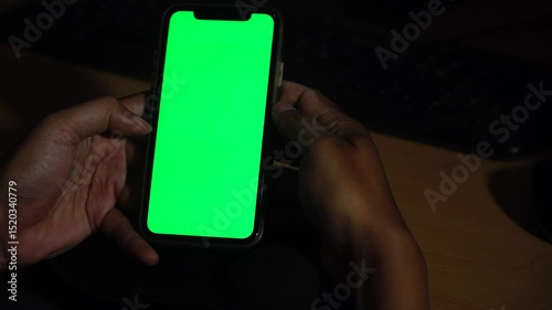 Man holds and swipes smartphone screen with chroma green screen