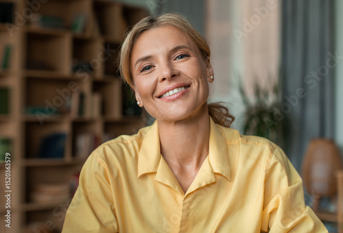 Foto Portrait of positive middle aged female psychologist talking to camera and smiling during therapy session in office
