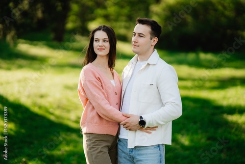 Couple enjoys a sunny day in a vibrant park full of lush greenery