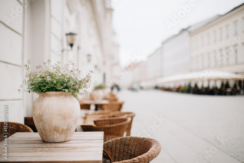 charming europeanstyle street cafe featuring single decorative sculpture surrounded by elegant outdoor furniture photo