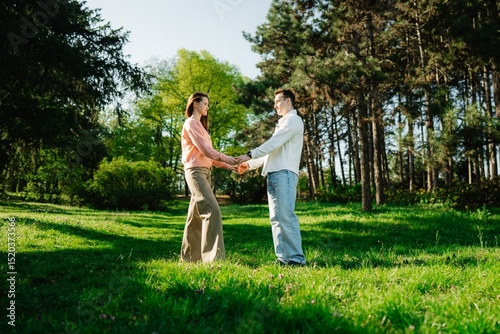Couple enjoys a romantic moment while holding hands in a sunlit park