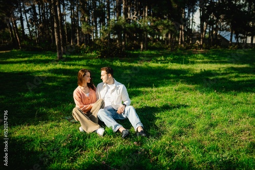 Couple enjoying a serene afternoon together in a sunlit green meadow