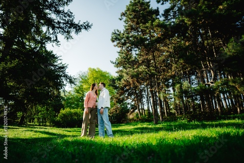 Couple sharing a tender moment in a serene forest clearing at sunset