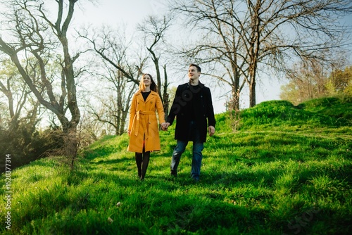 Couple strolled hand in hand through a vibrant green meadow at sunrise
