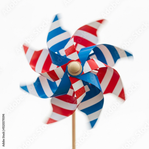 Close-up of a pinwheel toy in patriotic colors (red, white, blue) spinning in breeze, isolated on white background, clean look