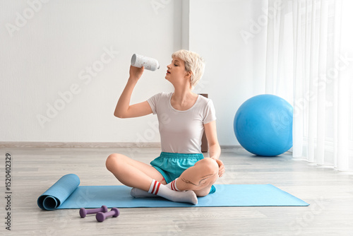 Sporty young woman  drinkin...