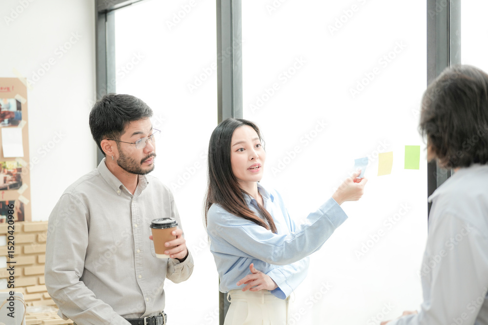 Fototapeta premium designers discuss creative ideas near a bright window in a modern office