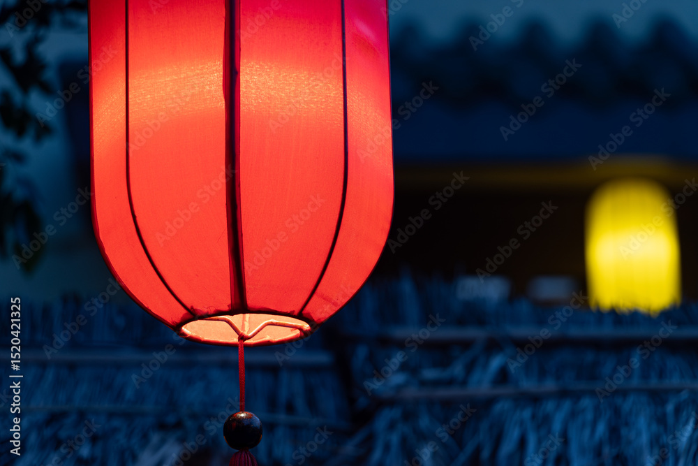 Obraz premium Glowing red and yellow hanging lanterns in a Buddhist temple, close up