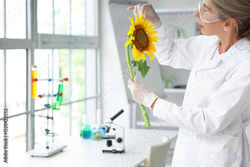 Female scientist with sunflower in laboratory