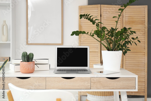 Blank laptop with plants on...