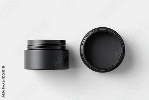 Two matte black cylindrical containers, one upright, one open, sit on a clean white background, showcasing their simple design