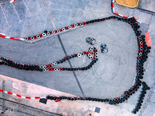 Exciting go-karting action on a winding outdoor track in sunny weather with colorful tires lined up for safety
