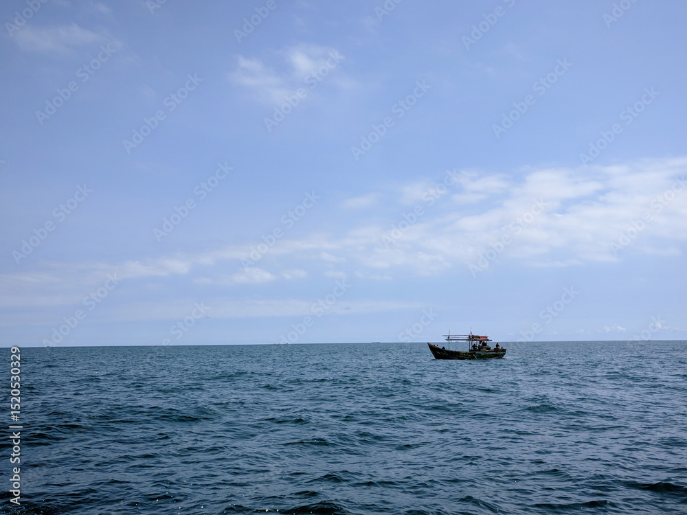 A small fishing boat floats alone on the calm, expansive blue ocean under a clear sky. A small fishing boat floats alone on the calm, expansive blue ocean under a clear sky.