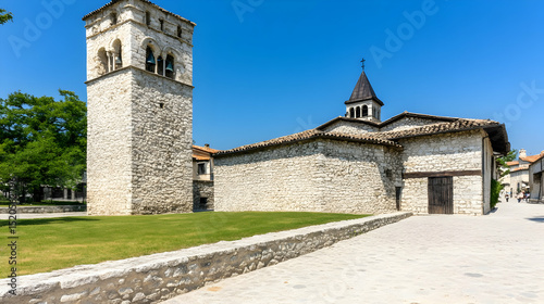 Historic stone church with medieval architecture and tower set in a European town surrounded by ancient walls and sky