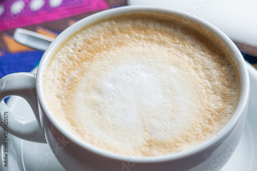 Close-up photo of a large cup of coffee with a focus on the texture of the coffee foam. photo