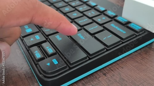 Close-up of businesswoman typing enter button on keyboard at desk