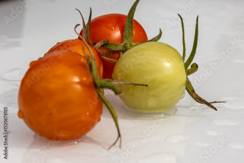 Freshly picked cherry tomatoes resting on a white surface