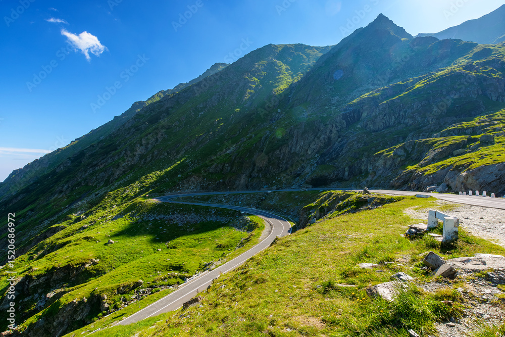 Naklejka premium romania travel landscape with road in summer. memorable journey through transylvania alps scenery in morning light. touristic destination of europe. sunny day with blue sky and fluffy clouds