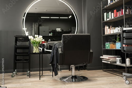 Fototapeta Naklejka Na Ścianę i Meble -  Modern hair salon interior with stylish black chair and circular mirror