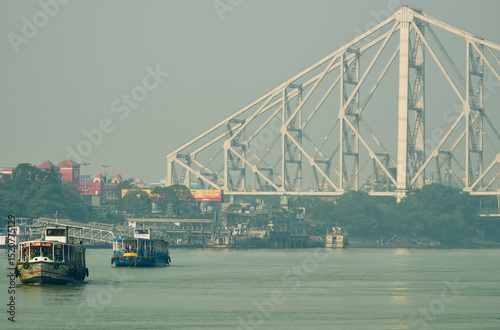 River ferries departing from the Howrah jetty on the Hooghly river with the Howrah Bridge in the background  at Calcutta, India