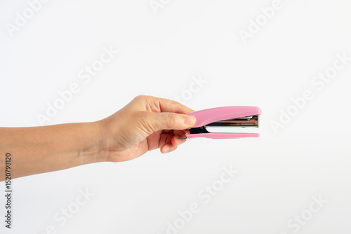 Pink stapler in hand on white background
