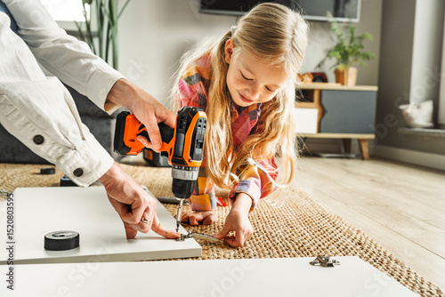 Father and daughter assembling furniture together at home