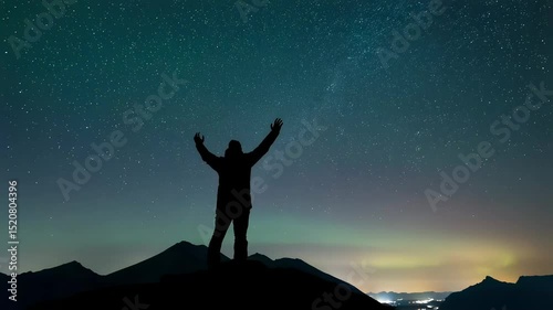 Silhouette Of Victorious Man Standing Against Night Sky Full Of Stars