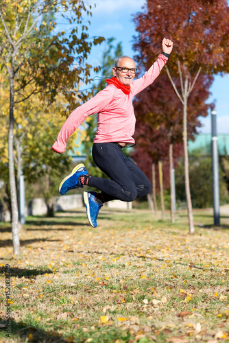 Senior man jumping high outdoors, showing energy and joy