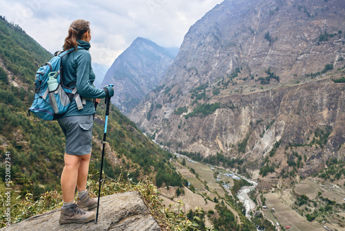 Hiker with backpack against picturesque mountain valley during Manaslu Circui...