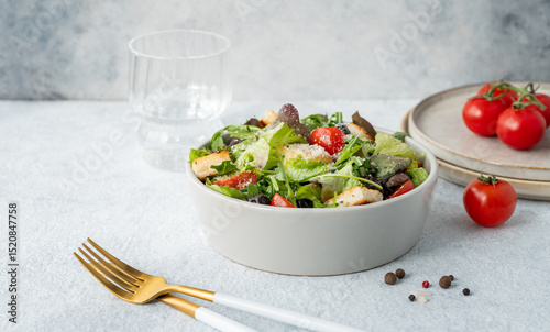 Vegetarian salad with lettuce, tomatoes, croutons, olives and parmesan cheese in a bowl