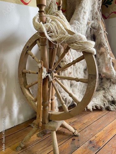 Wooden spinning wheel with threads, spindle