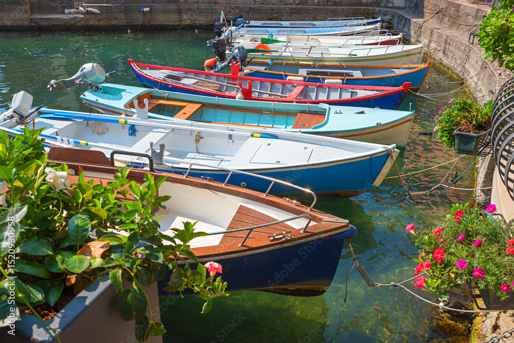 Obraz premium moored colorful motor boats at small harbor Limone