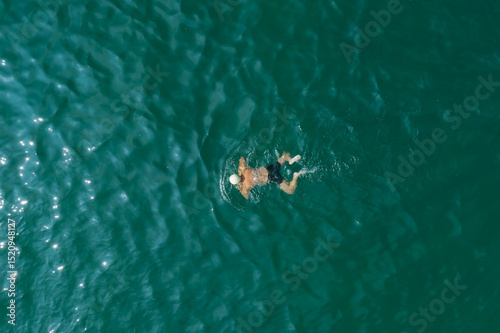 Aerial photography of people swimming in the sea, taken in Dalian, Liaoning Province, China
