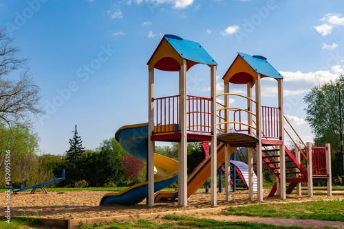 Wallpaper Mural Vibrant children’s playground with slides, stairs, and sandy ground in a park setting on a sunny day. Torontodigital.ca