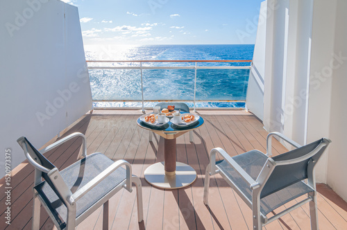 Petit déjeuner sur la terrasse d'une cabine balcon d'un navire de croisière avec vue dans le sillage du bateau. 