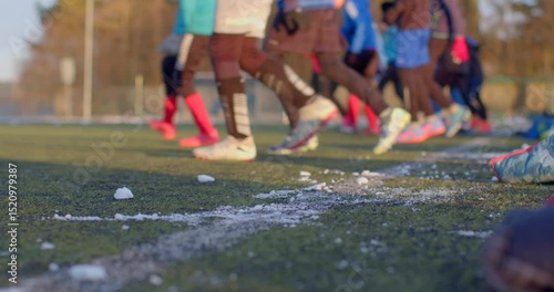 Players engage on a large outdoor field, with visible ice fragments scattered in the background